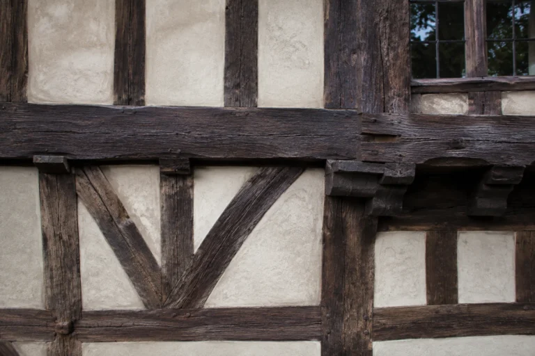 Façade de maison à colombages avec poutres de chêne et enduit à la chaux rénovés